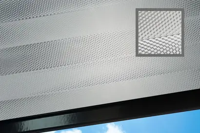 Geprägt und plissierter Folienbehang mit Zoom auf die Zick-Zack-Plissierung, an einem Fenster.