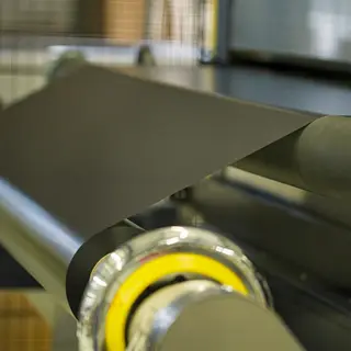 Glatte Rollofolie wird in der Produktion von einer Maschine aufgerollt.