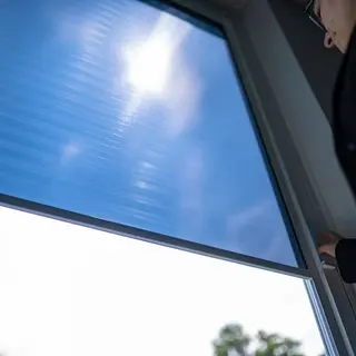 Ein Fenster mit Sonnenschutzrollo.